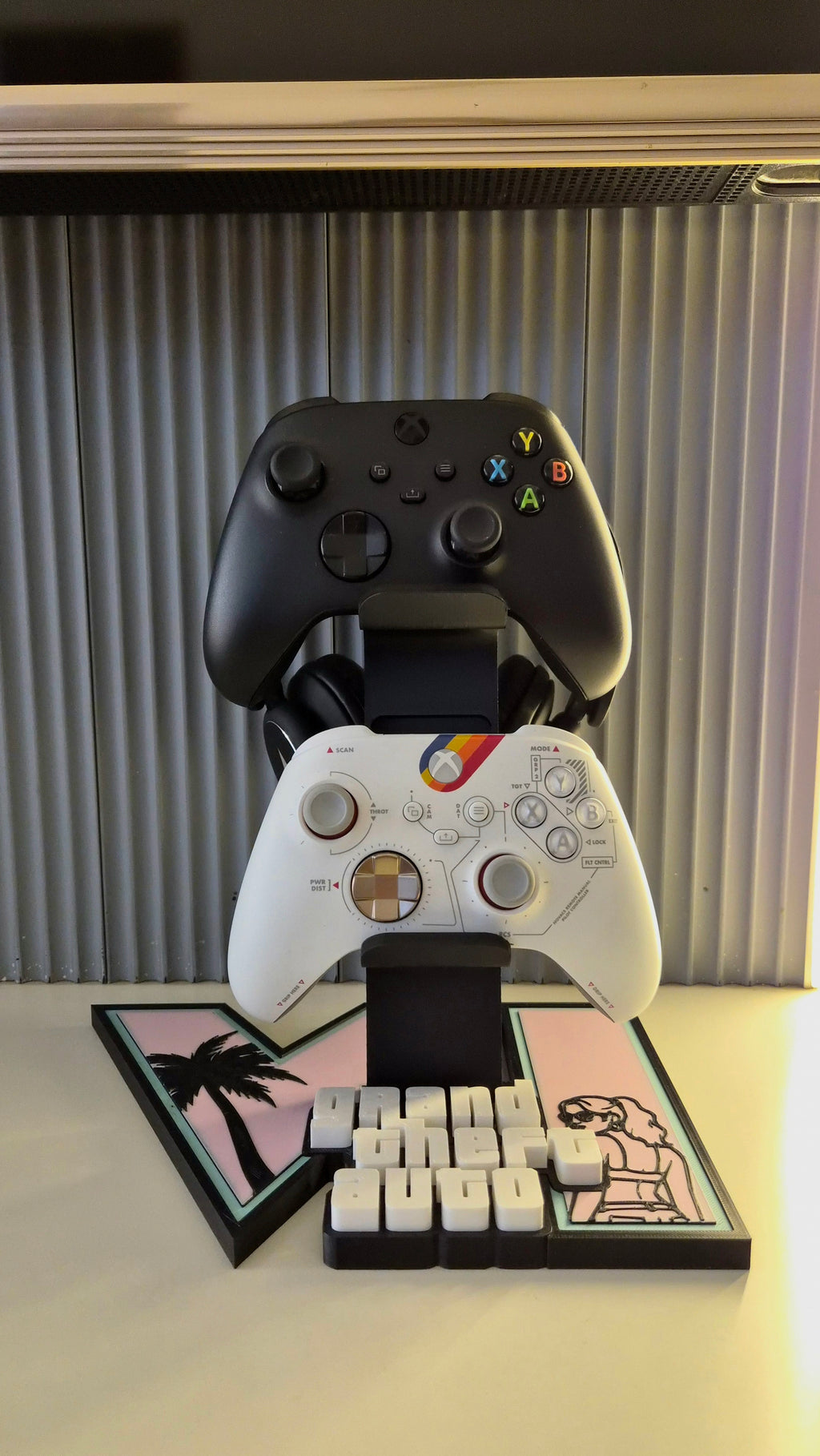 Front view of GTA 6 themed controller and headset stand with two controllers on a pink and mint display base