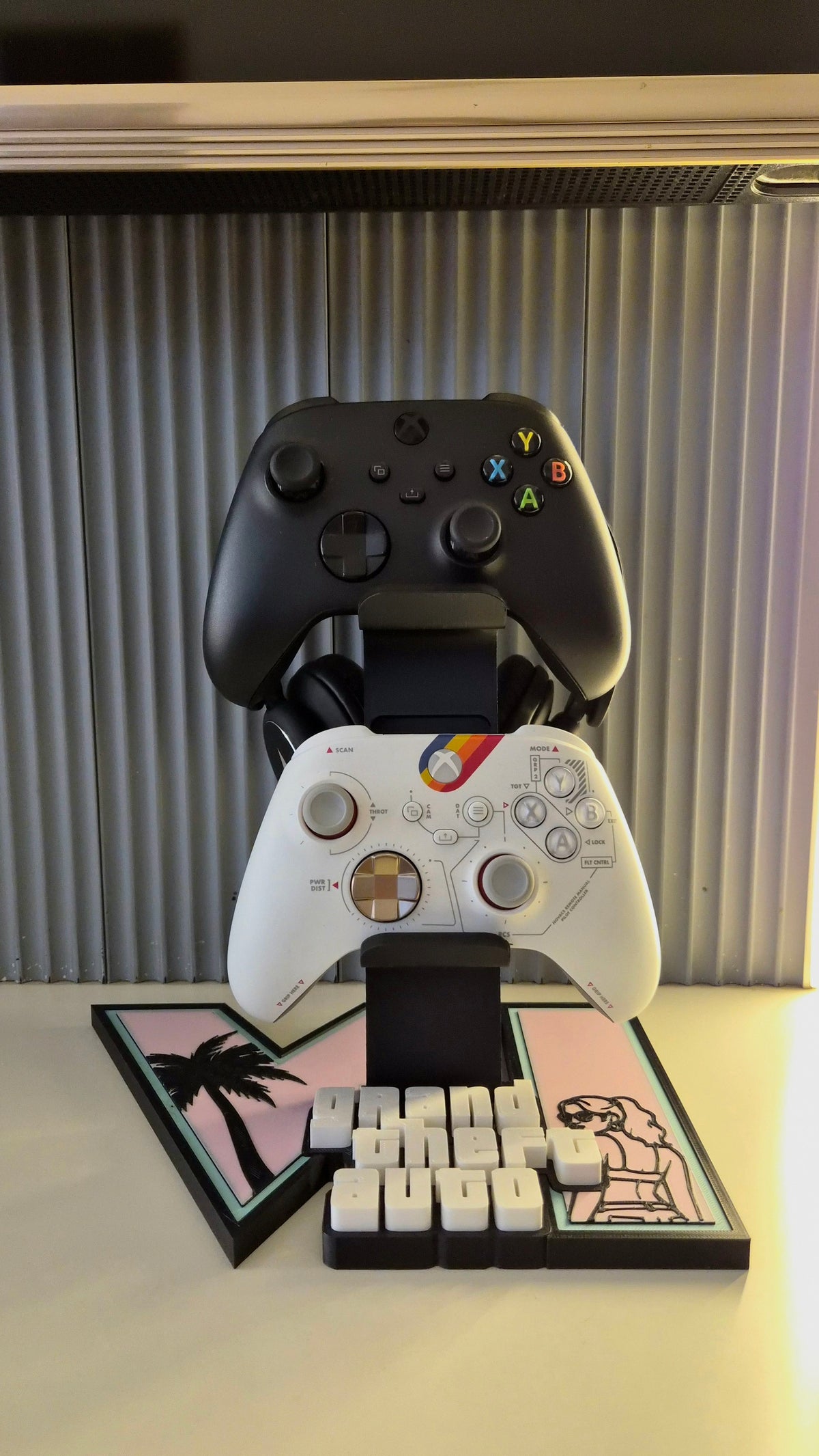 Front view of GTA 6 themed controller and headset stand with two controllers on a pink and mint display base